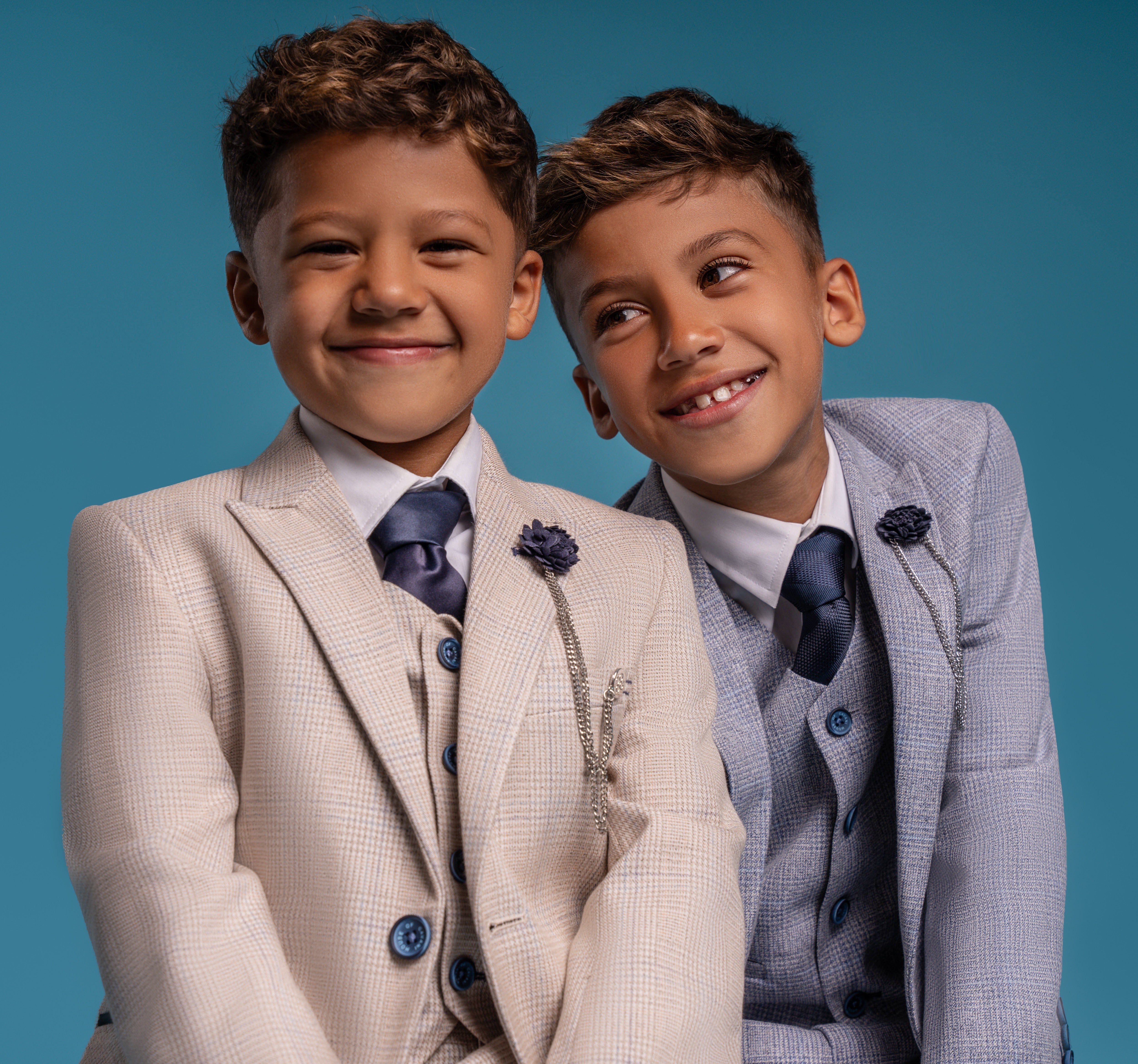 Two little boys wearing dapper suits to a summer wedding