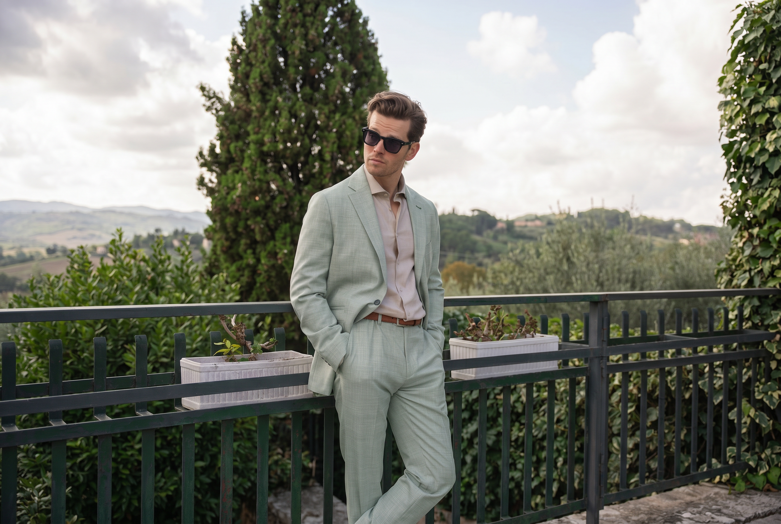 A man wearing a 2-piece sage green linen suit in a smart casual way.