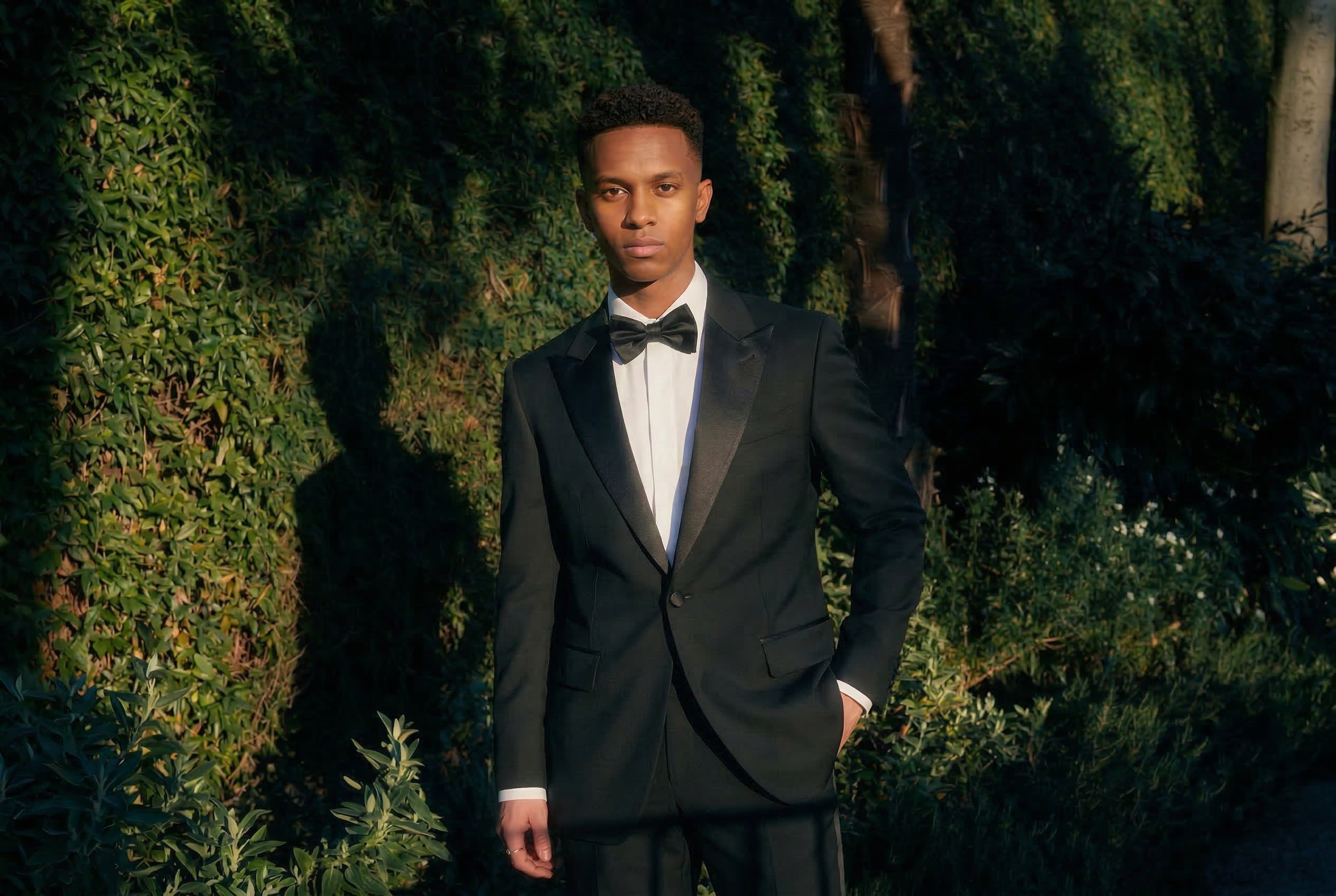 A young man wearing a patterned tuxedo suit to prom.