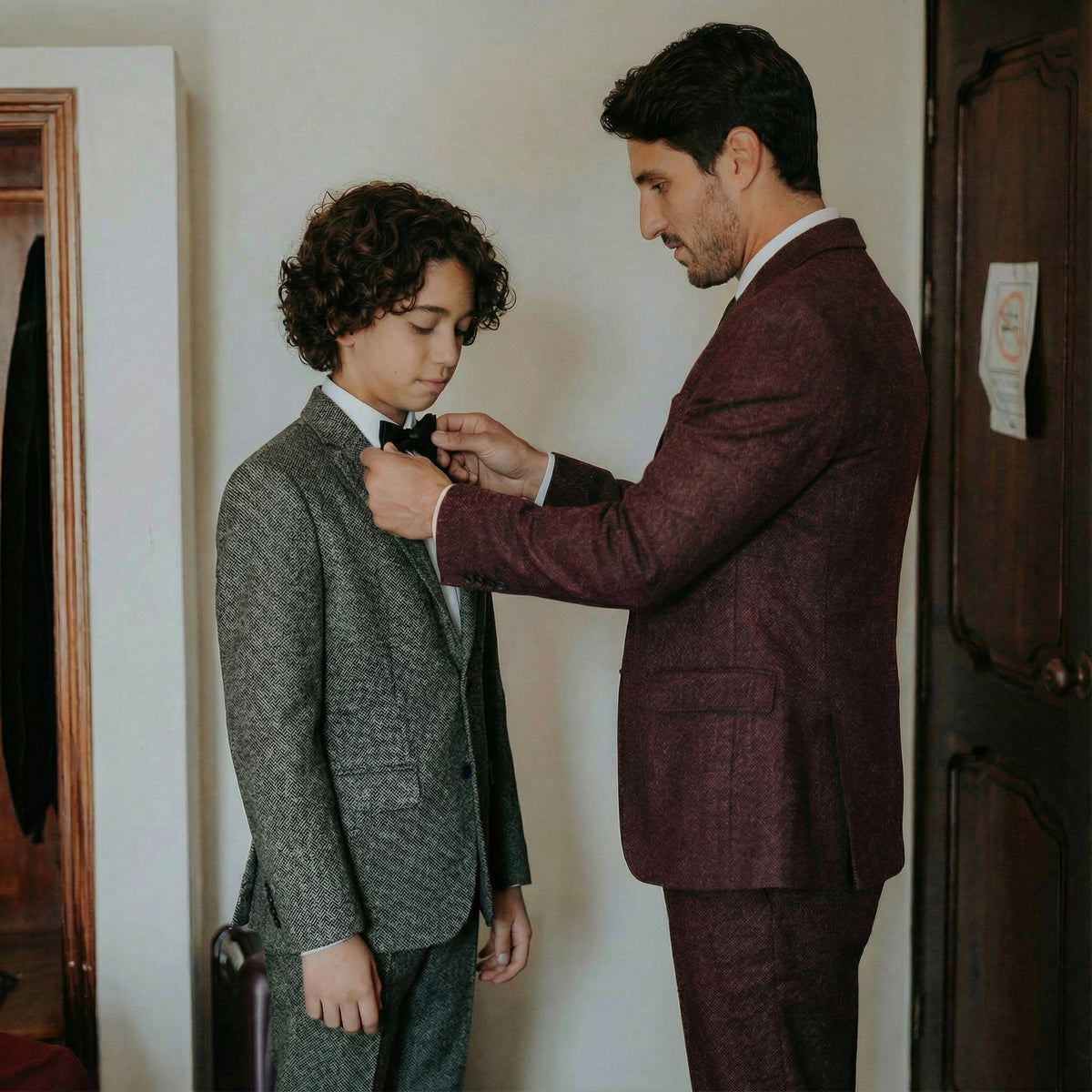 A man and boy posing together wearing wool tweed suits