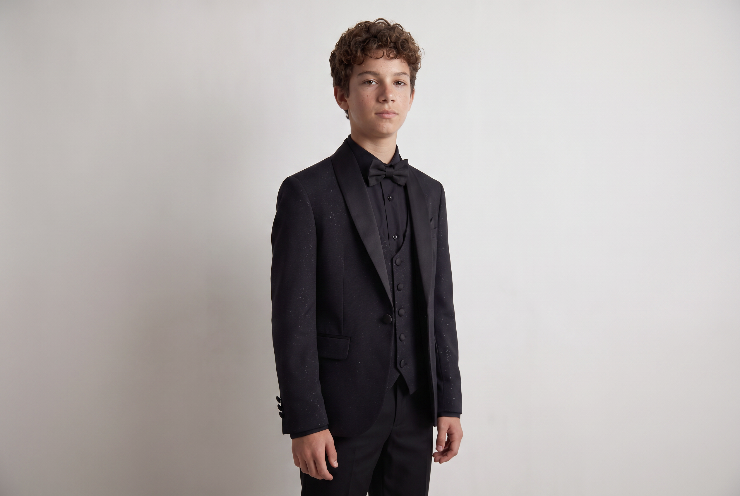 Teenage boy in a black suit, an example of what a boy might wear to a funeral.