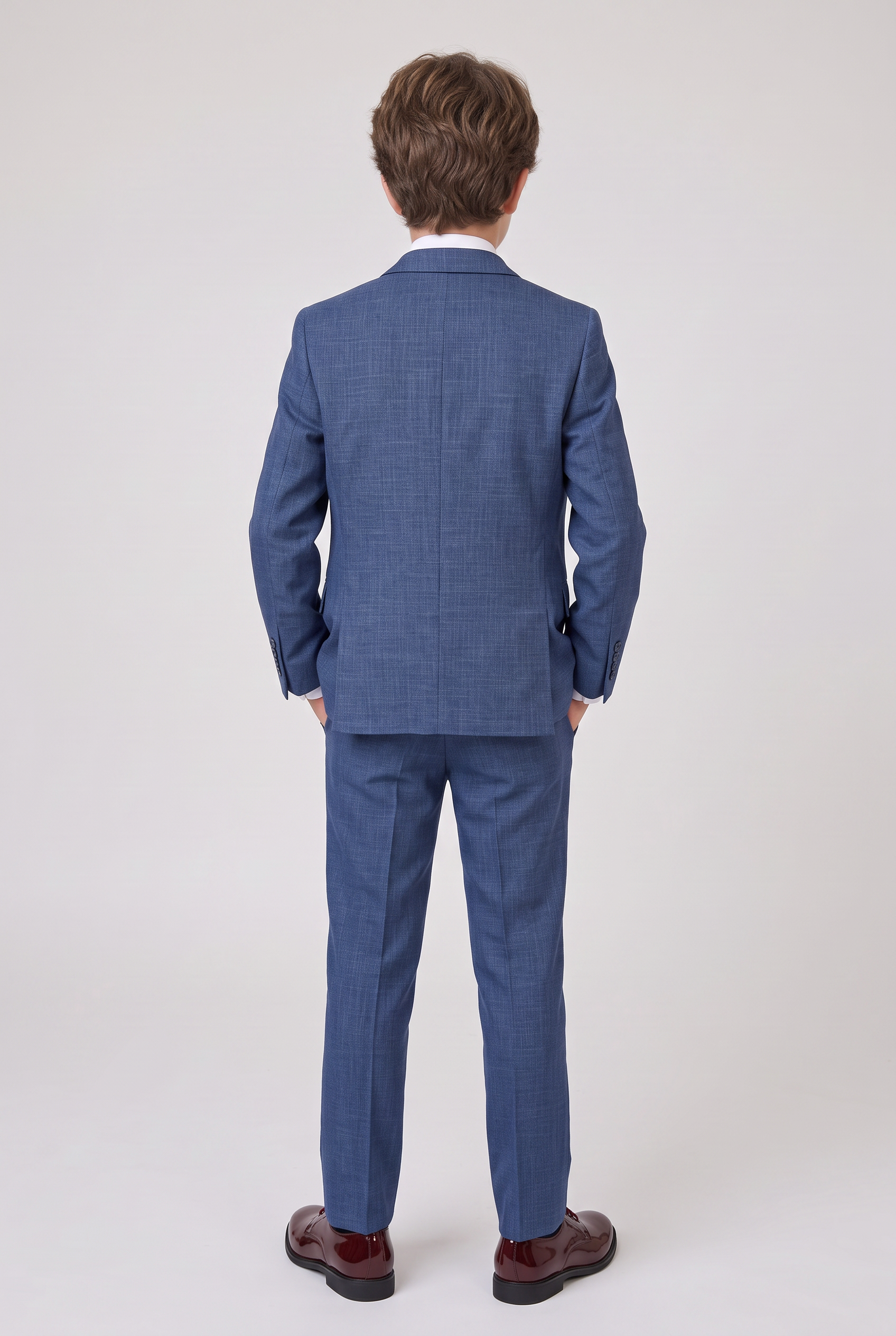 Back view of boy wearing navy three-piece suit