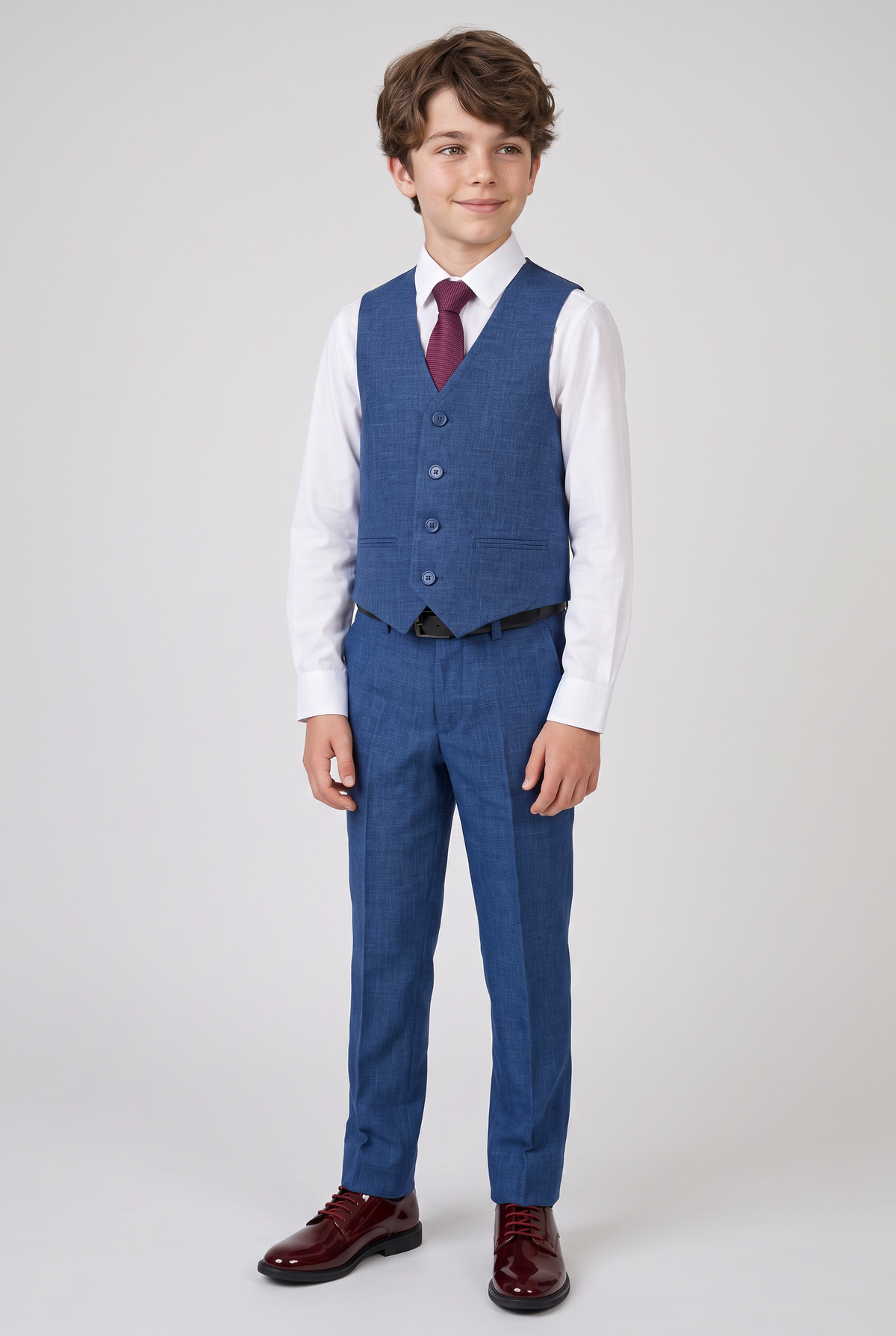 Boy wearing navy waistcoat and trousers with burgundy tie
