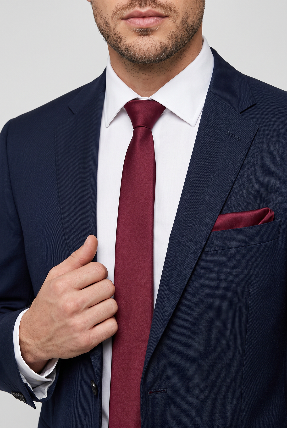 Burgundy satin tie and pocket square styled with a navy suit