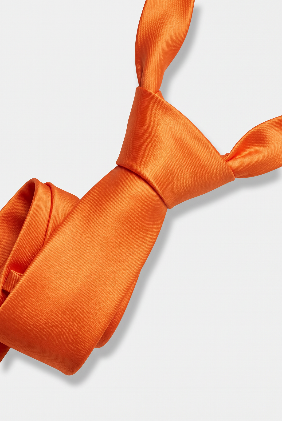 Orange satin necktie showing knot and fabric texture close-up