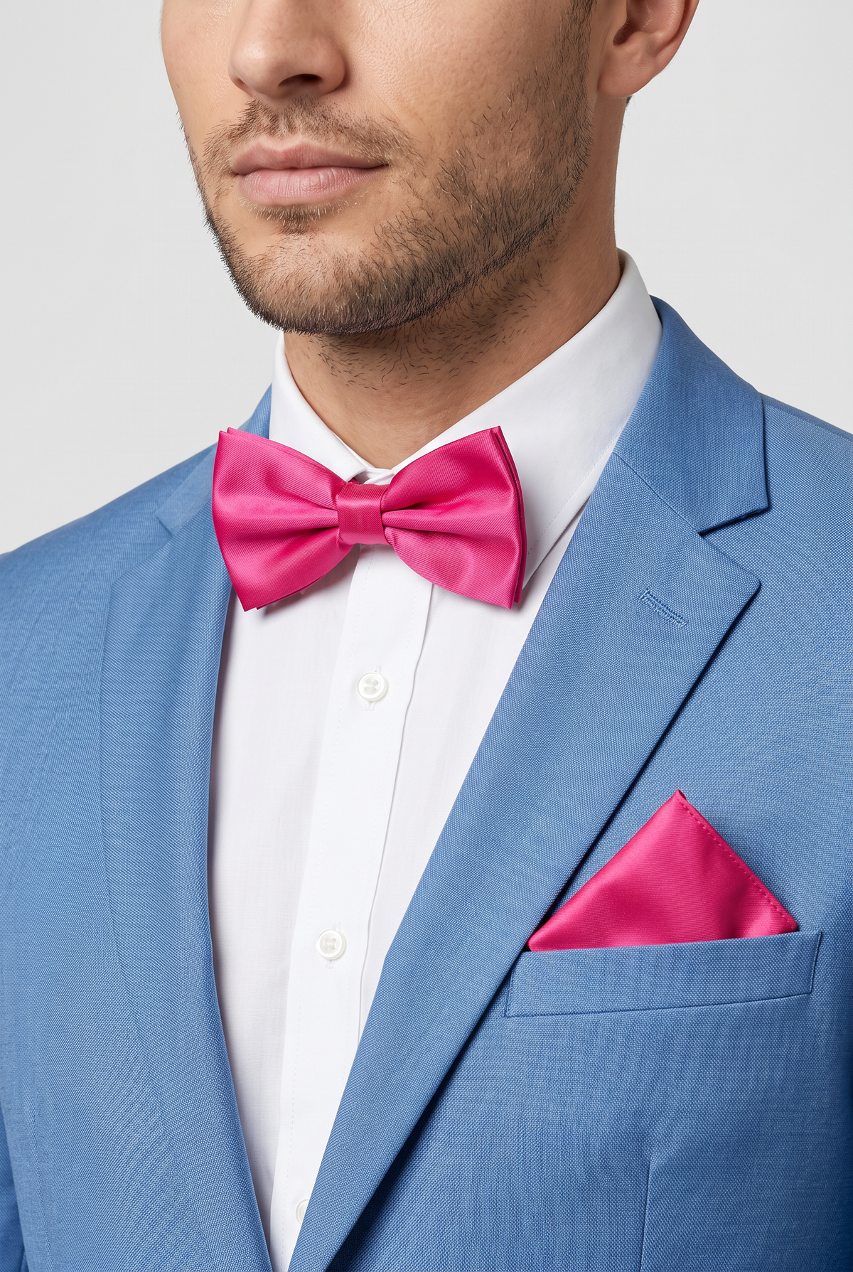 Men wearing a fuchsia satin bow tie and matching pocket square with a suit