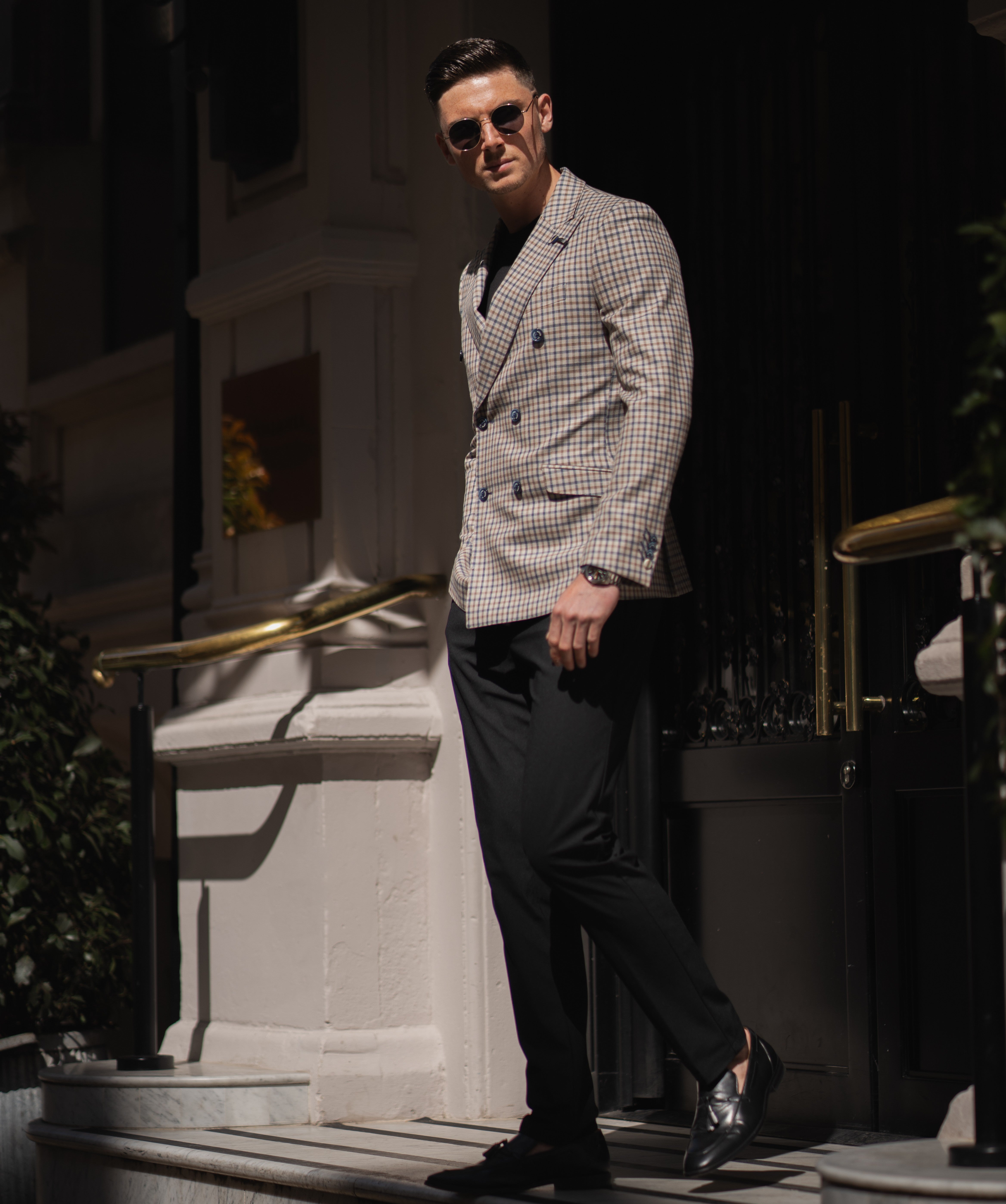 A man wearing a plaid double-breasted blazer, looking dashing and sharp.