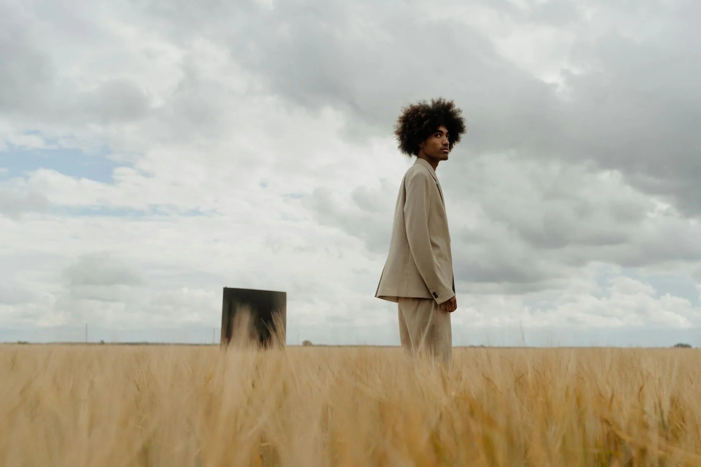 A man in a field wearing spring summer 2025 sustainable linen blazer and trousers