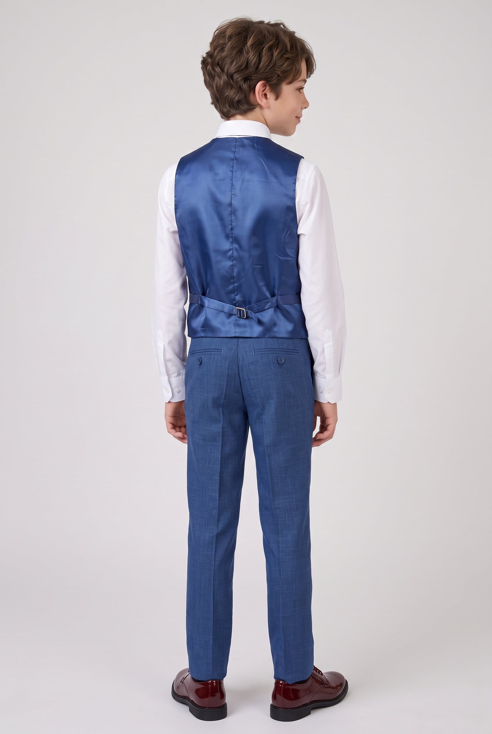 Back view of boy wearing navy suit vest and trousers