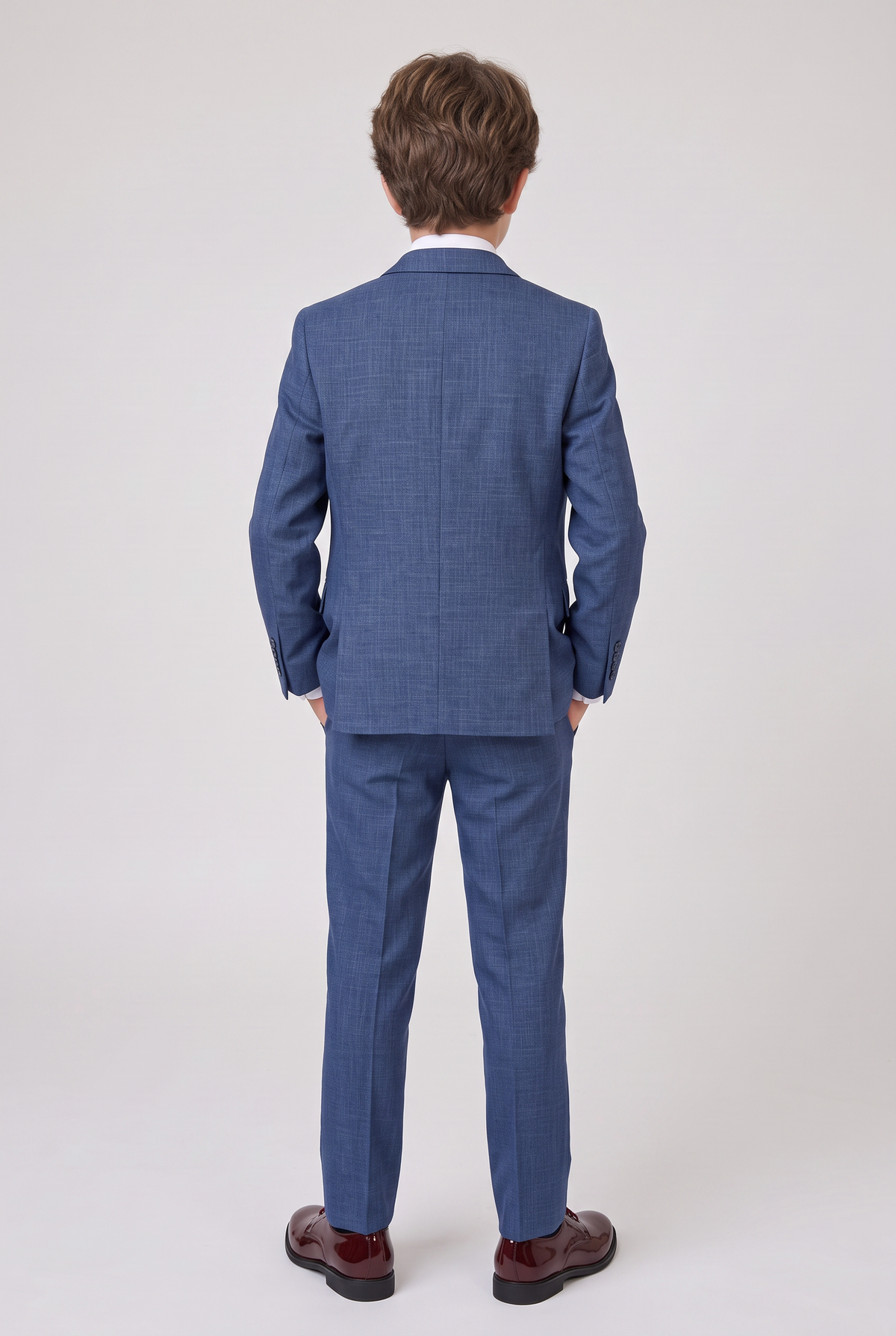 Back view of boy wearing navy three-piece suit