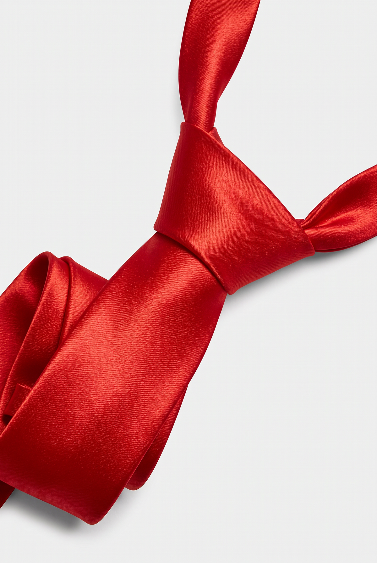 Red satin necktie showing knot and fabric texture close-up 